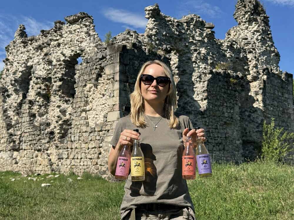 Сидр чи вино: Яна Матвійчук демонструє різні смаки сидру MONBAR біля старовинної фортеці.